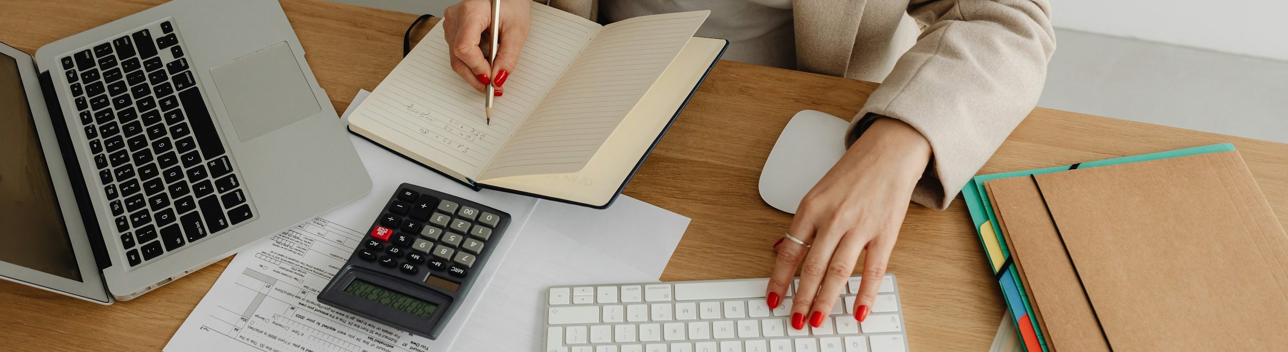 Asesoramiento contable y fiscal Profesional trabajando con documentación contable, portátil y calculadora